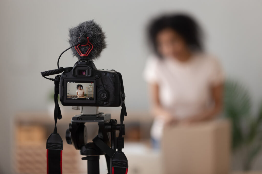 Vlogger using digital camera close up, recording parcel unboxing