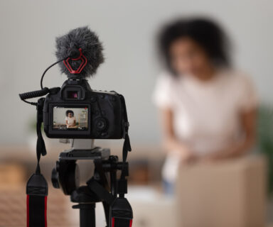 Vlogger using digital camera close up, recording parcel unboxing