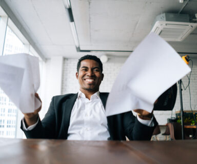 Close-up-low-angle-view-of-angry-African-American-business-man-throwing-up-paper-account-documents-scream-shout