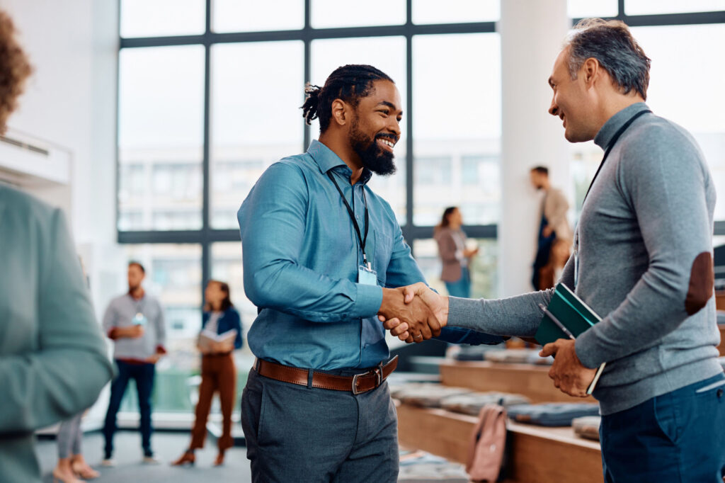 Happy-businessmen-greeting-while-attending-an-education-event-at-conference-hall