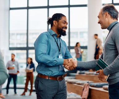 Happy-businessmen-greeting-while-attending-an-education-event-at-conference-hall