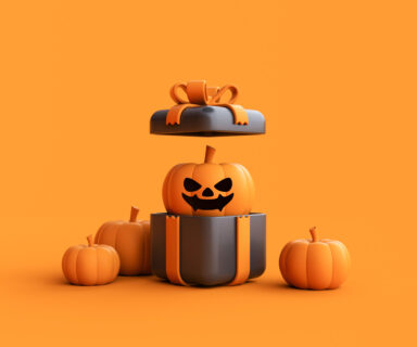 Opened gift box with Halloween Jack-o-Lantern pumpkin wearing witch hat on orange background.