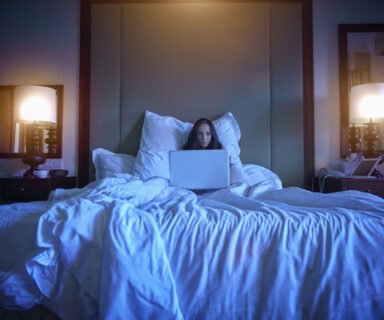 Pacific Islander woman using laptop in bed