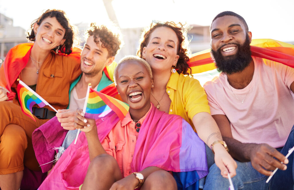 Portrait-diversity-and-rainbow-flag-for-lgbtq-community-freedom-and-smile-for-parade-support-or-solidarity.-Friends-group-or-young-people-with-non-binary-gay-and-lesbian-with-