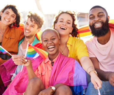 Portrait-diversity-and-rainbow-flag-for-lgbtq-community-freedom-and-smile-for-parade-support-or-solidarity.-Friends-group-or-young-people-with-non-binary-gay-and-lesbian-with-