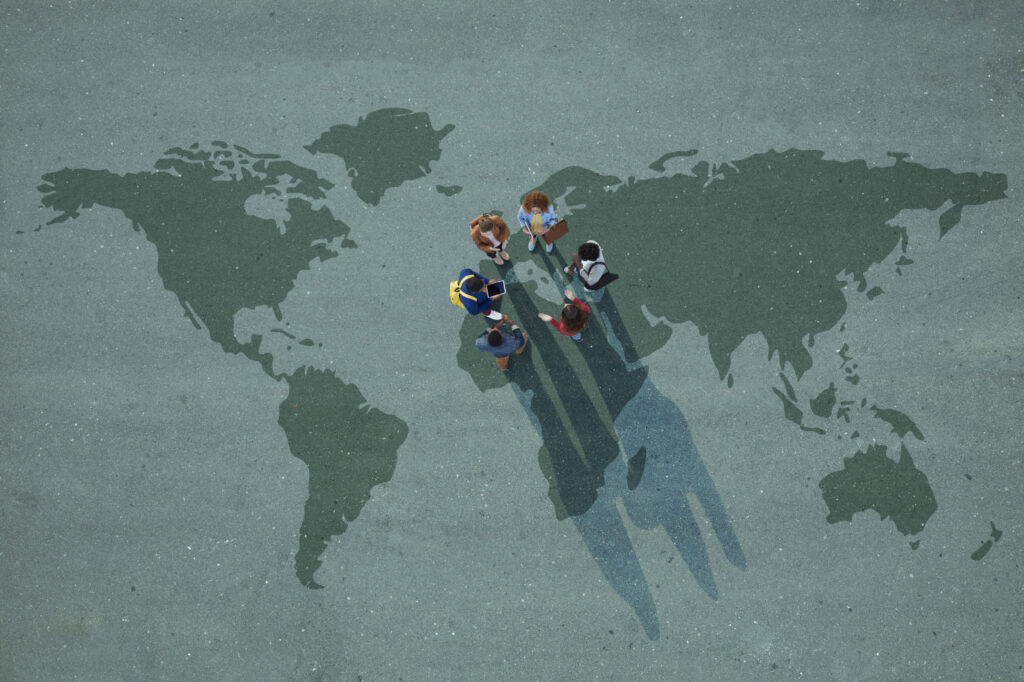 Top-view-of-group-of-people-standing-on-worldmap-painted-on-asphalt