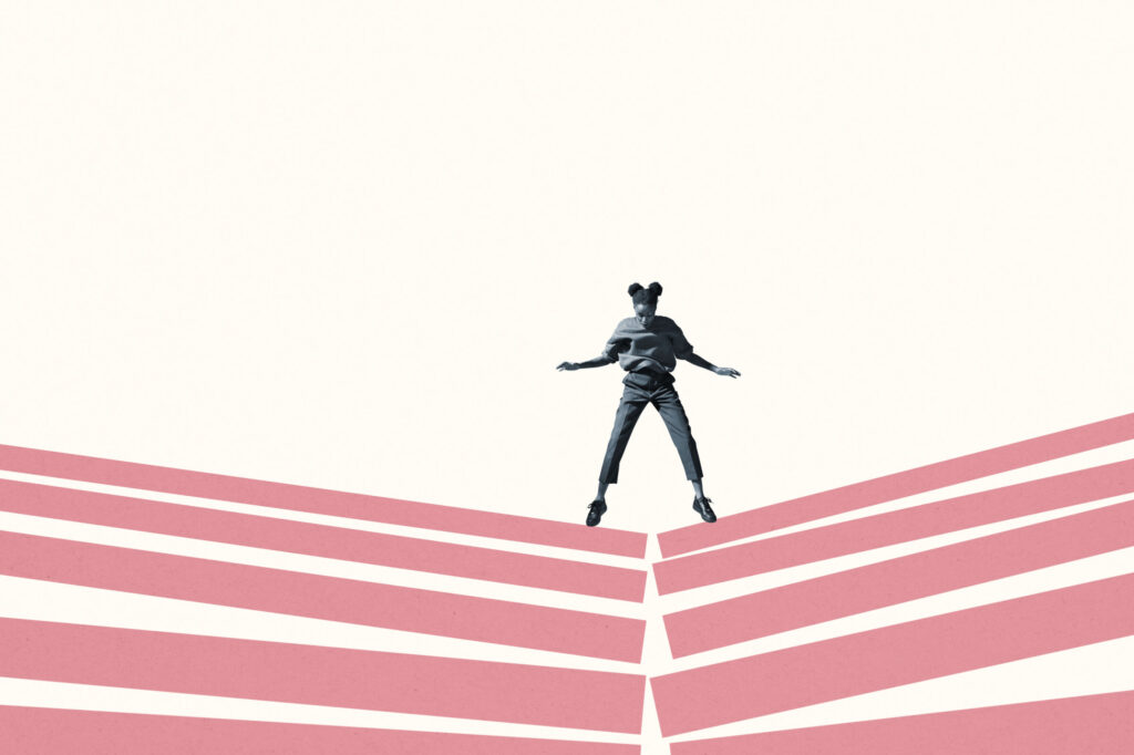 Woman jumping on broken pink block stacks