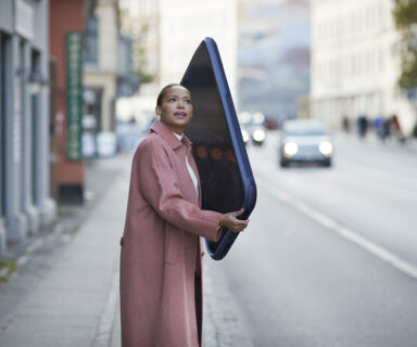 Woman talking on large mobile phone on sidewalk in city